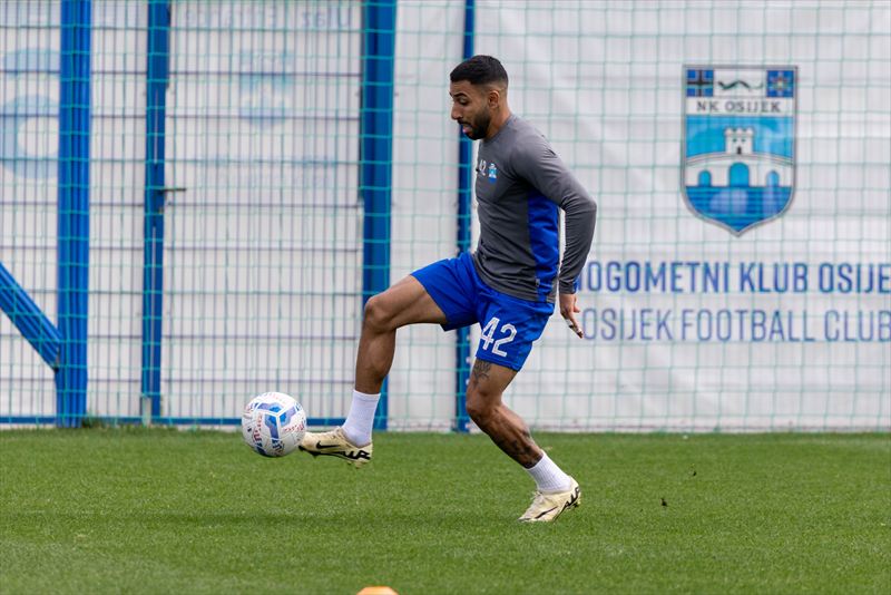 Renan Guedes treina com bola junto ao alambrado do centro de treinamento do NK Osijek.